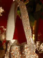 Decorative handbag with pearl and crystal embellishments on a blurred background