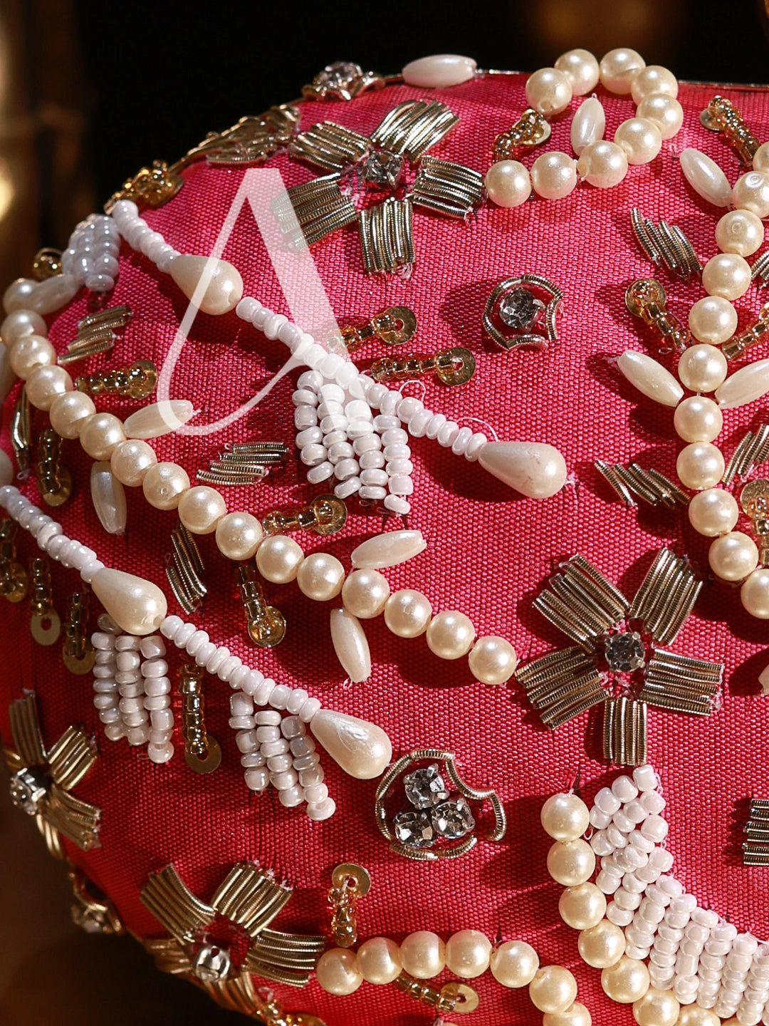 Close-up of pearl and gold jewelry on a red fabric background