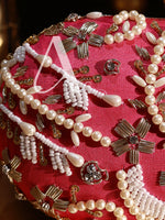 Close-up of pearl and gold jewelry on a red fabric background
