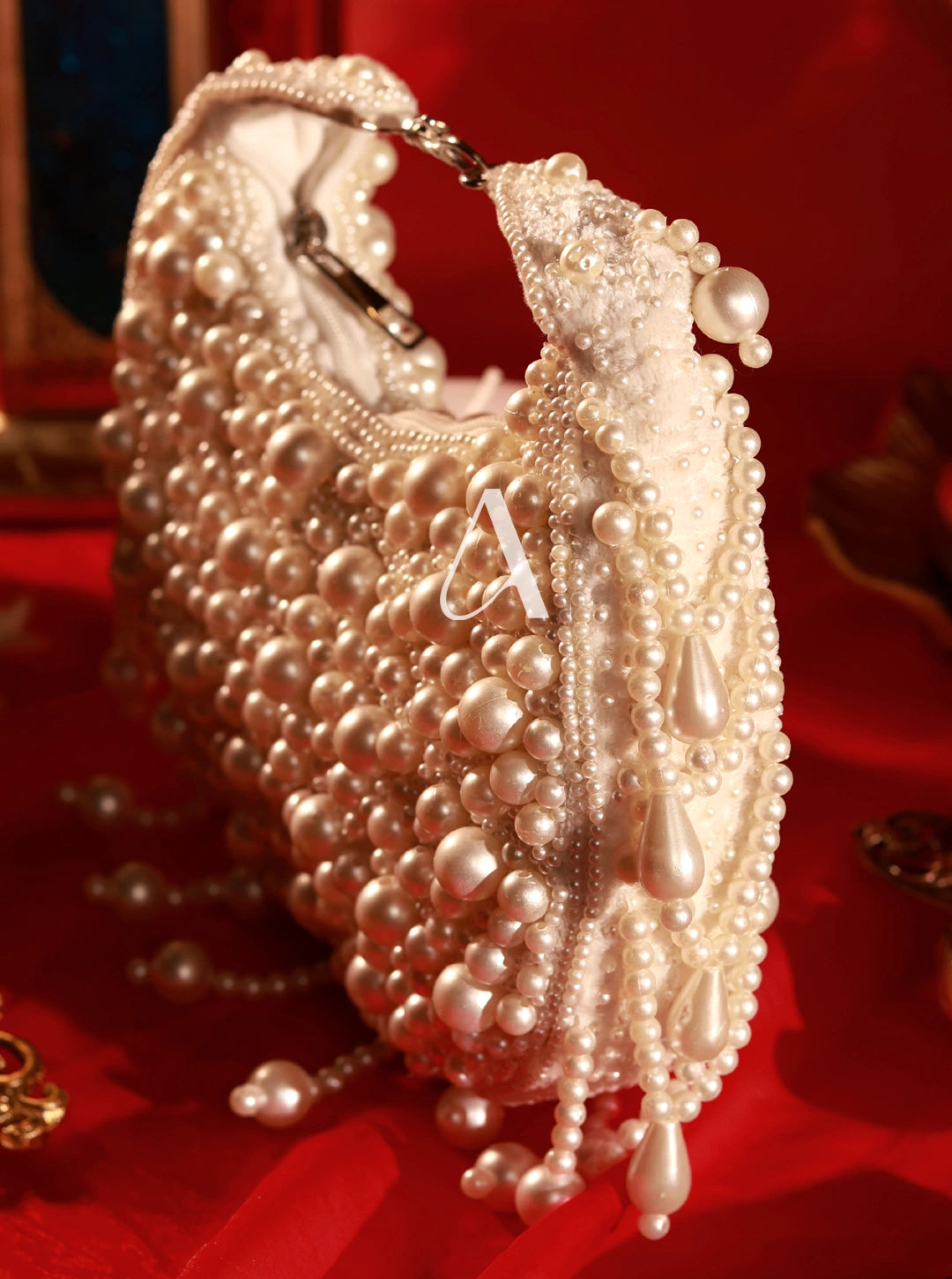 Pearl-handled handbag with decorative elements on a red background