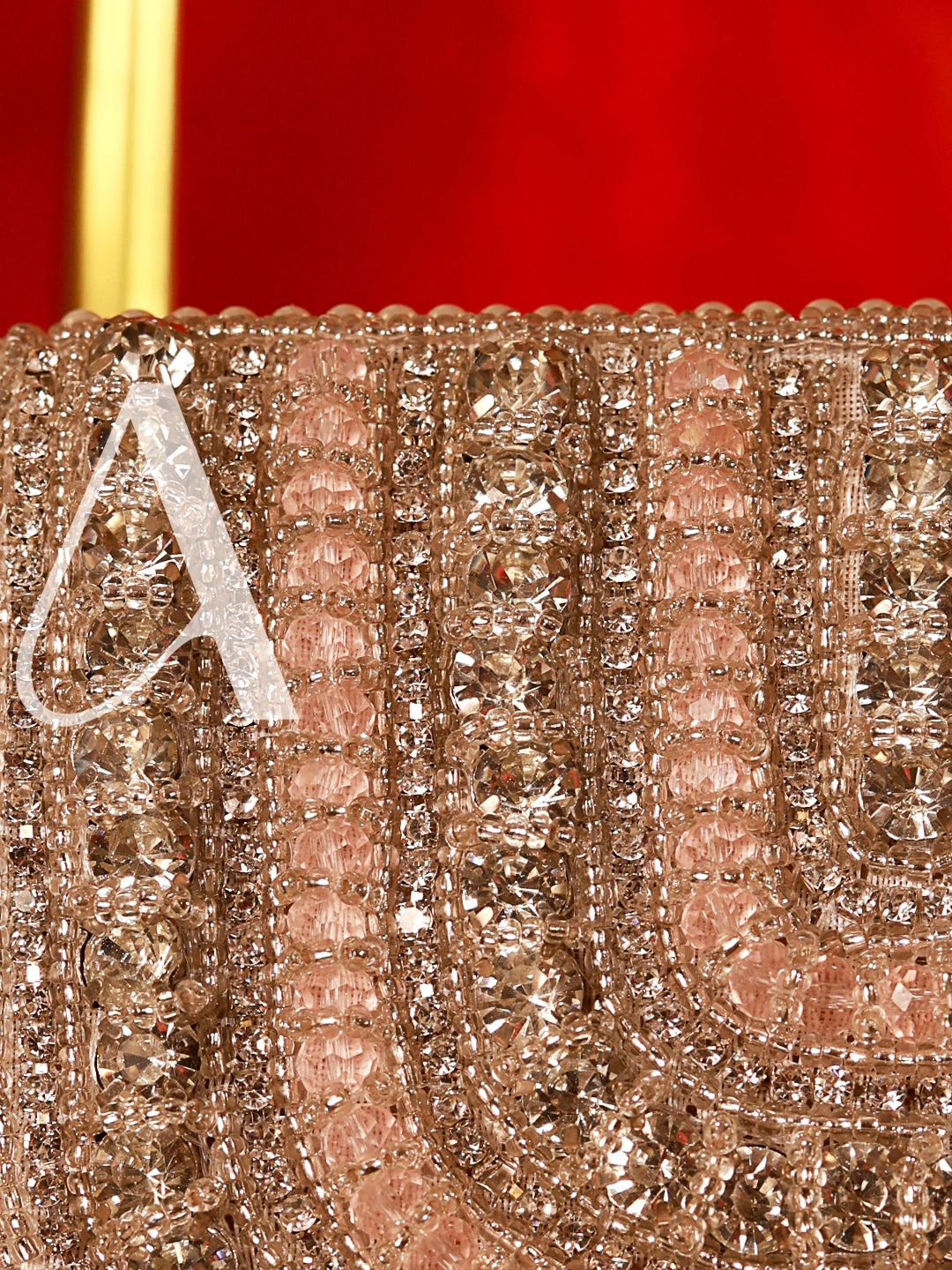 Close-up of a decorative item with intricate patterns and a letter 'A' on a red background